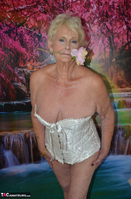 Blondie old lady Sparkle takes off a corset while getting nude in her bedroom