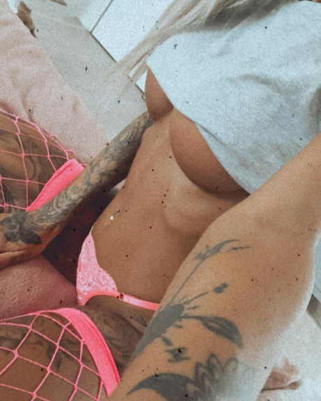 Tattooed amateur babe poses in pink fishnets & flaunts her hot legs & cleavage - #161809