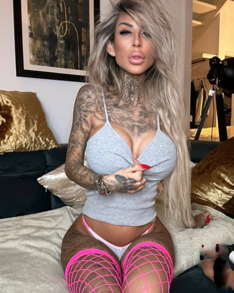 Tattooed amateur babe poses in pink fishnets & flaunts her hot legs & cleavage - #161811