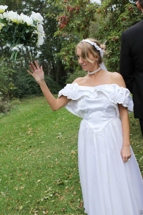 Blonde bride Hayley Marie Coppin gets undressed on a lawn while taking her vows