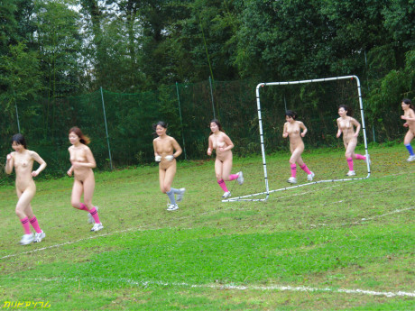 Oriental female football team watches as a teammate gets nailed by the referees