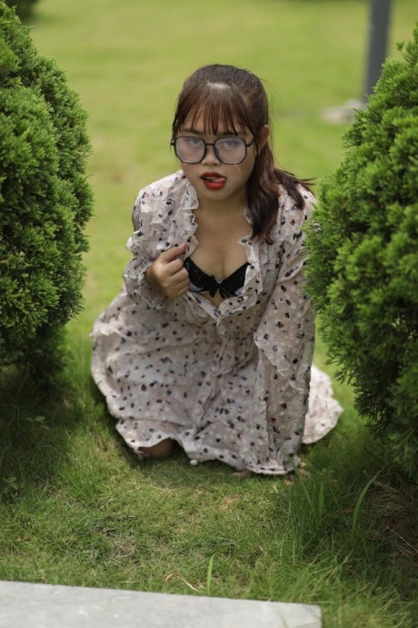Sweet slut girl broad exposes her brassiere while kneeling between a couple of shrubs - #279510