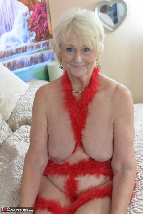 Blondie old lady Sparkle models nude on a bed while draped in red garland - #315745