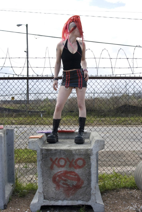 Punk slut GF lady with red hair poses naked in platform boots at industrial site